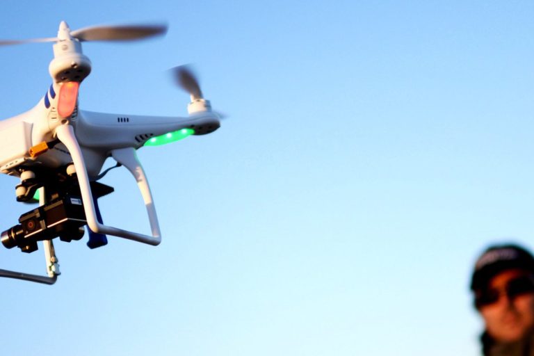 Un dron levantando en vuelo siendo visualizado por su operador.